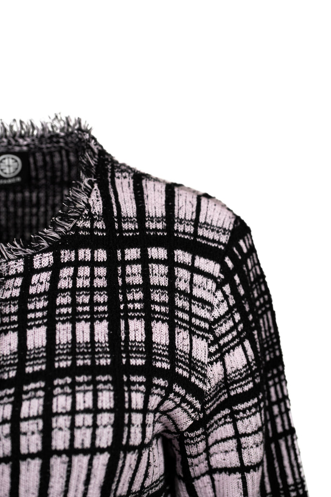 Detailansicht - Klassische Bouclé-Jacke in Rosé mit schwarzem Karomuster, durchgehender Knopfleiste und dekorativen Fransenabschlüssen an Kragen, Saum und Ärmeln. Zwei kleine Pattentaschen auf Hüfthöhe unterstreichen den eleganten Look im Chanel-Stil.