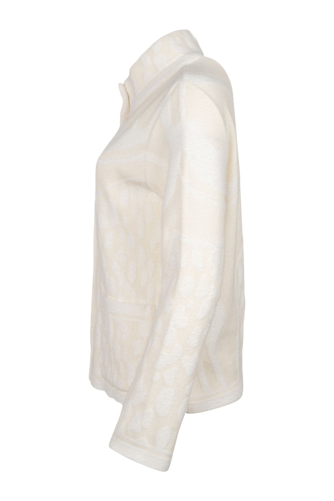 Seitenansicht - Cremefarbene Strickjacke mit Stehkragen, durchgehender Knopfleiste und aufgesetzten Taschen. Strukturierte Strickmuster sorgen für einen hochwertigen, gemütlichen Look – ideal für kühle Tage.