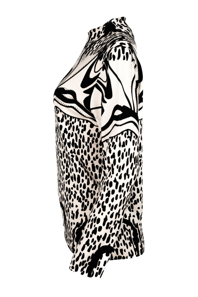 Seitenansicht - Langarmshirt mit Stehkragen und auffälligem Schwarz-Weiß-Print. Das Design kombiniert abstrakte Linien mit Animal-Print-Elementen und floralen Details zu einem modernen, grafischen Statement-Piece.