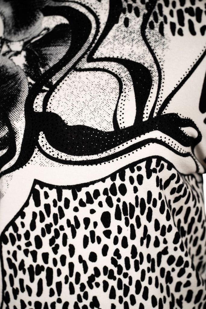 Detailansicht Druck - Langarmshirt mit Stehkragen und auffälligem Schwarz-Weiß-Print. Das Design kombiniert abstrakte Linien mit Animal-Print-Elementen und floralen Details zu einem modernen, grafischen Statement-Piece.