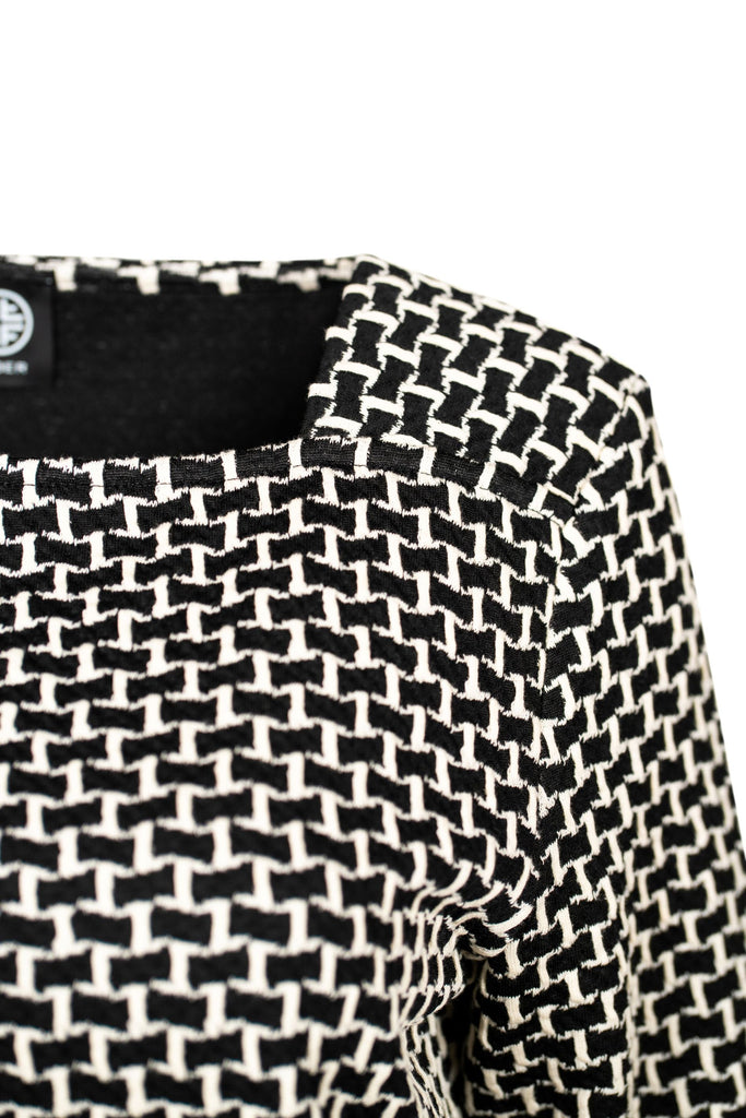 Detailansicht Schulter - Langarmpullover mit geradem Schnitt und grafischem Allover-Muster in Schwarz-Weiß. Der eckige Ausschnitt verleiht dem modernen Design eine elegante Note – ideal für Büro oder Freizeit.