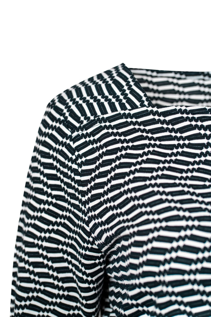 Detailansicht Schulter - Langarmshirt mit schmalem geradem Ausschnitt und schwarz-weißem Wellenmuster. Der grafische Allover-Print verleiht dem figurnah geschnittenen Shirt eine moderne, optisch spannende Wirkung.